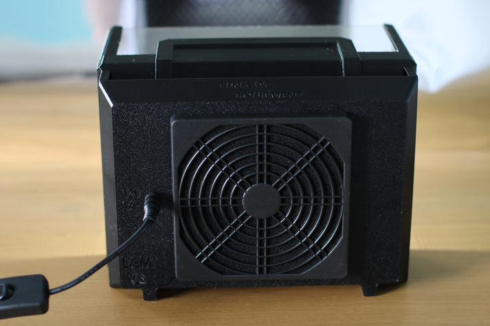 Rear view of the small laminar flow hood, showing the fan and power input. The device is compact and has a black, sturdy build.